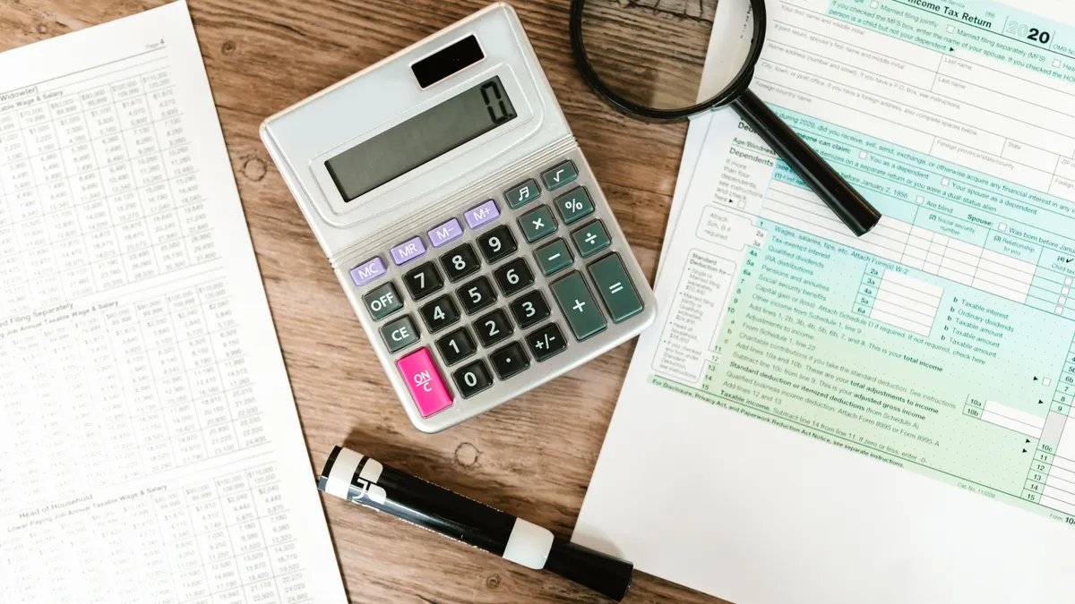 2026 federal income tax brackets explained Calculator, pen, and magnifier on tax documents