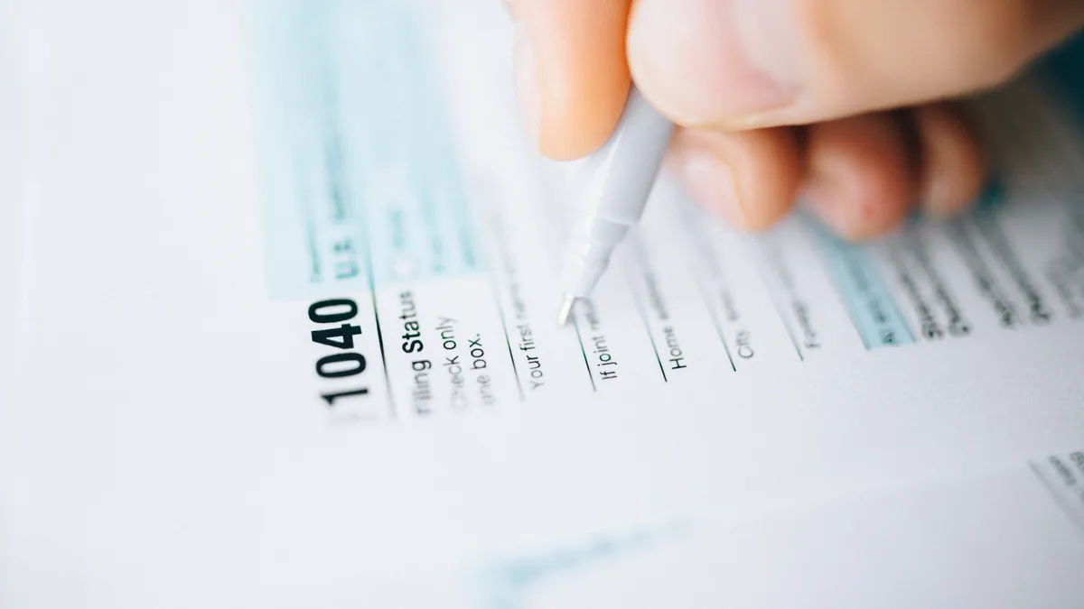 Child tax credit: who qualifies and how it works Hand writing on a 1040 tax form